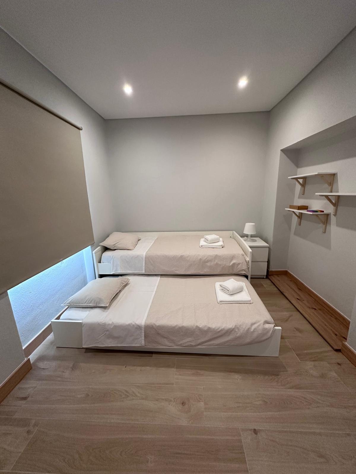 Quarto aconchegante com 2 camas de solteiro em formato extensível
